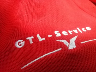 Haft logo GTL-Service na czerwonej koszulce polo